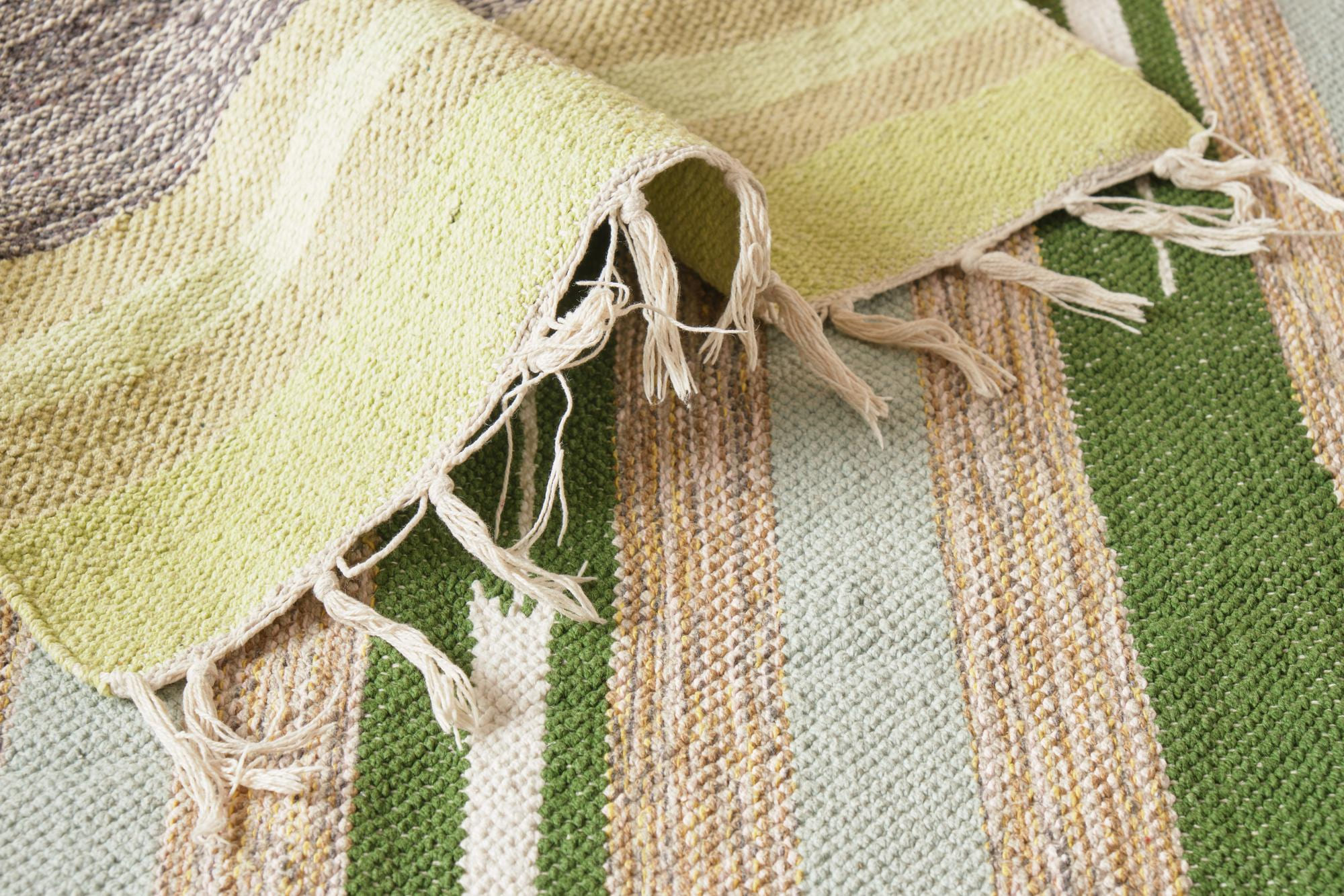 Cotton carpet with natural texture in green and beige tones